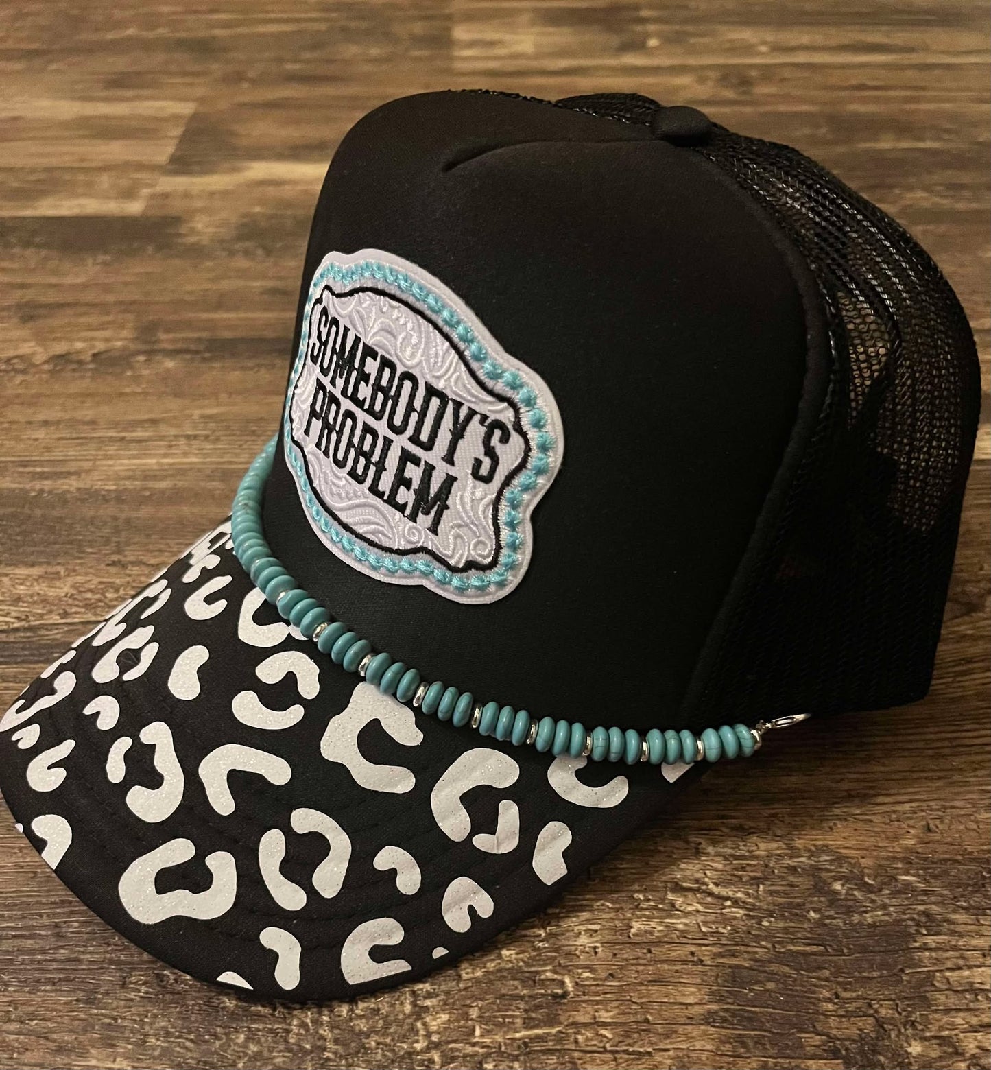 SOMEBODY'S PROBLEM CHEETAH BRIM TRUCKER HAT